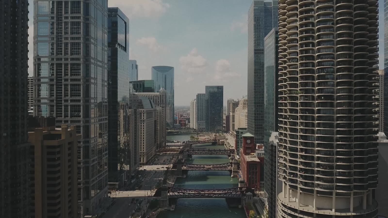 Drone flying down the river corridor between skyscrapers