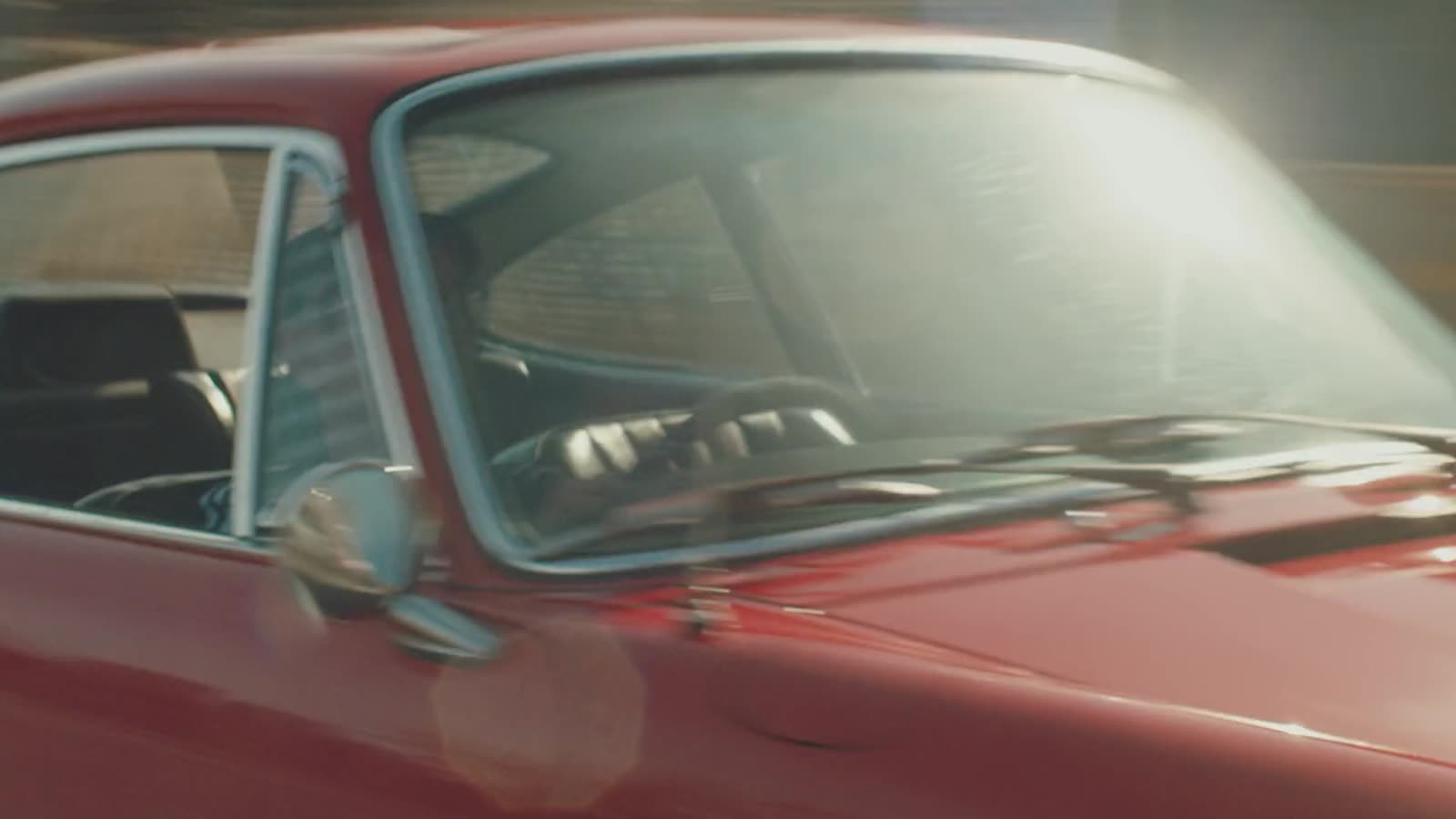 A red 1960s Porsche 911 at a petrol station