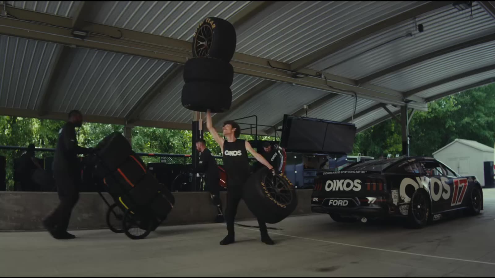 Crew member carrying a balanced stack of tires